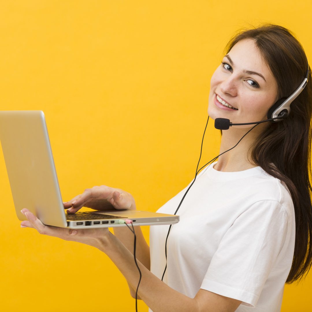 side-view-woman-wearing-headset-smiling-holding-up-laptop